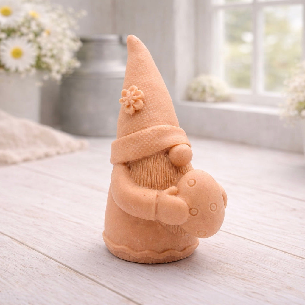 A detailed handmade vegan soap gift,  sculpted as a whimsical Easter gnome (gonk) wearing a tall pointed hat with a flower detail, holding a large patterned Easter egg.