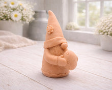 Load image into Gallery viewer, A detailed handmade vegan soap gift,  sculpted as a whimsical Easter gnome (gonk) wearing a tall pointed hat with a flower detail, holding a large patterned Easter egg.
