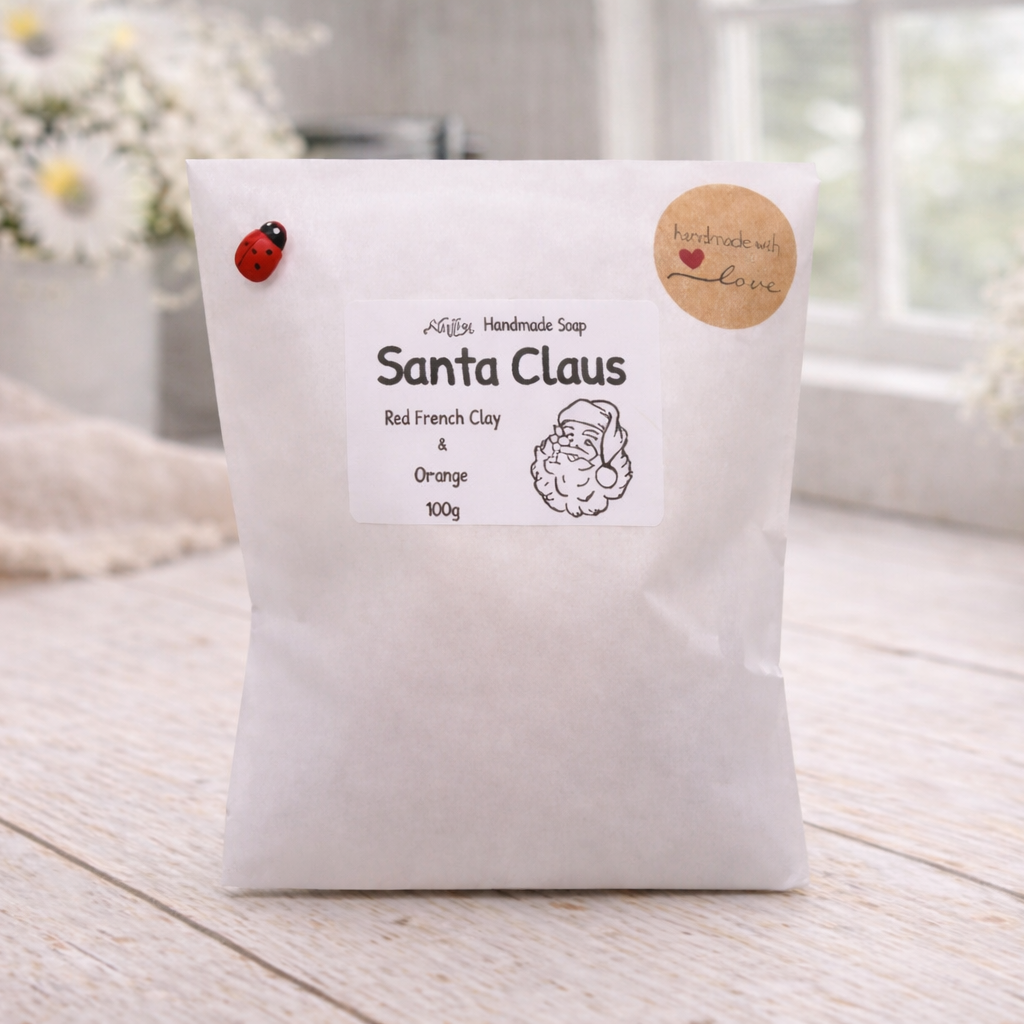 White bag with 'Santa Claus' soap label on a wooden surface with flowers in the background