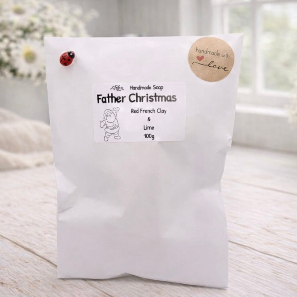 White soap package with 'Father Christmas' branding on a light wooden surface.