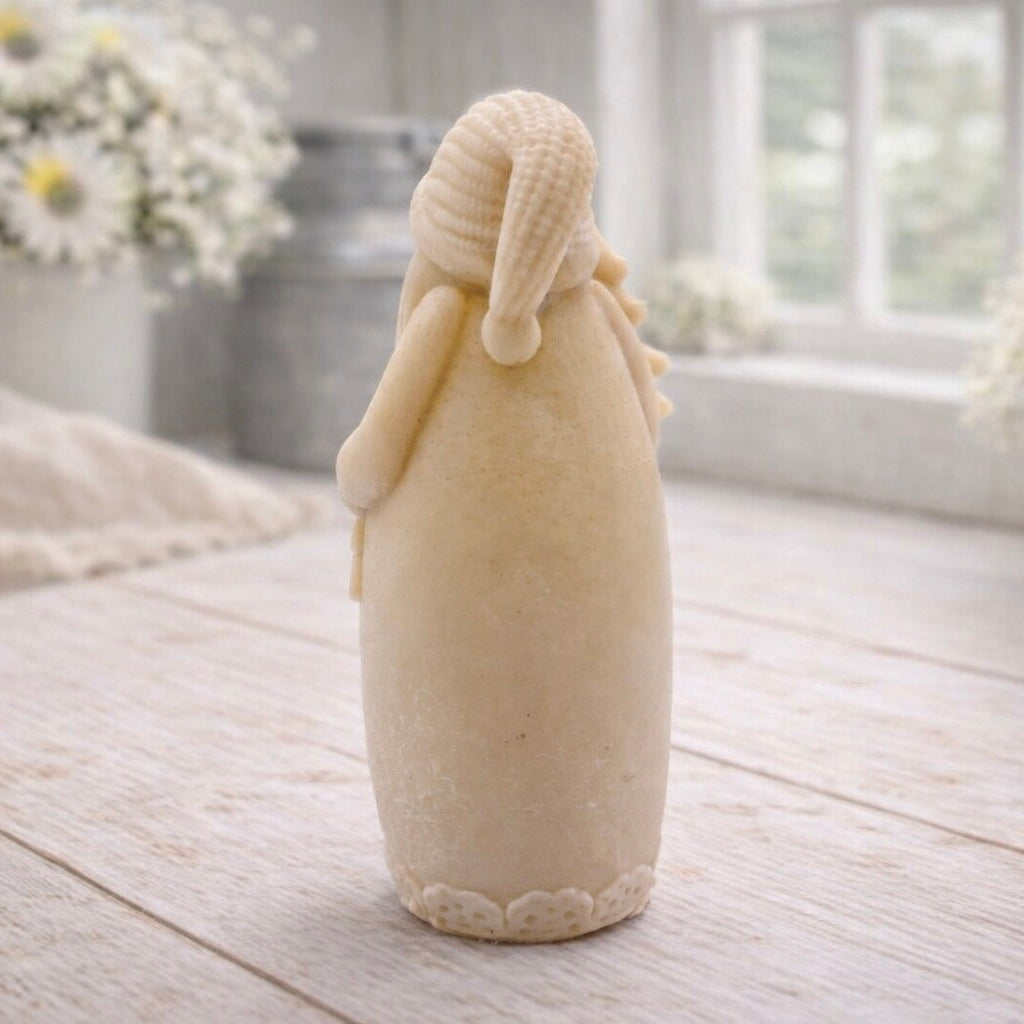 handmade vegan soap sculpted into a tall figure of Father Christmas wearing star-patterned robes, holding a small Christmas tree in one arm and a lantern in the other, set in a bright farmhouse window.