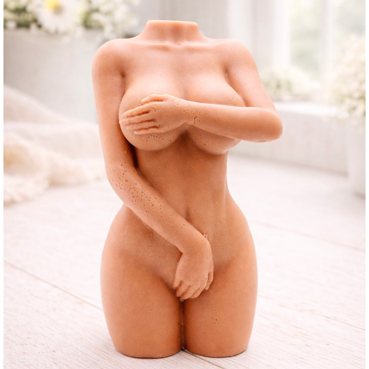 A handmade vegan soap sculpted into a detailed female torso with soft, realistic curves and defined musculature and displayed in a bright farmhouse setting.