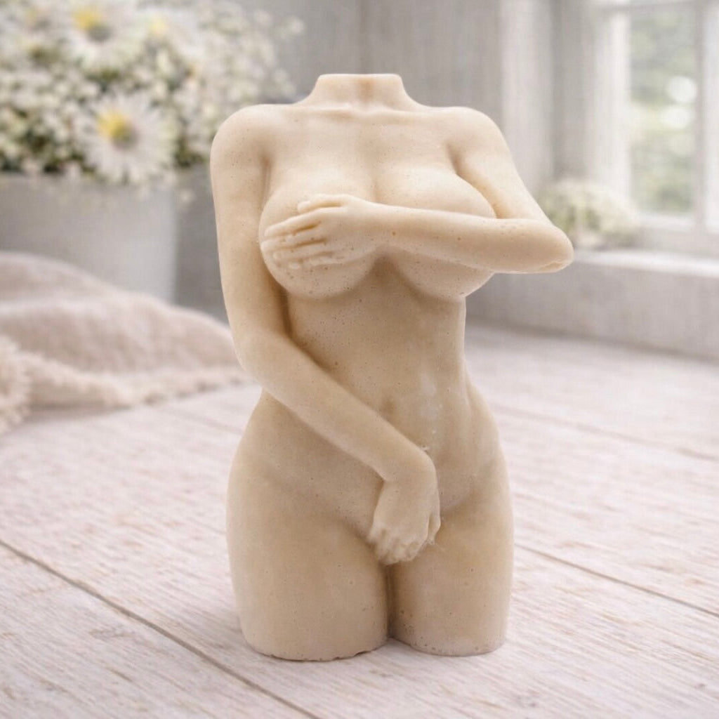 A 3D handmade vegan soap sculpted into a detailed female torso with soft, realistic curves and defined musculature and displayed in a bright farmhouse setting.