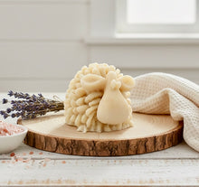 Load image into Gallery viewer, A highly detailed handmade vegan soap sculpted in the shape of a fluffy sheep with thick, textured wool and a smooth face, displayed on a light wooden surface in a farmhouse-style setting.
