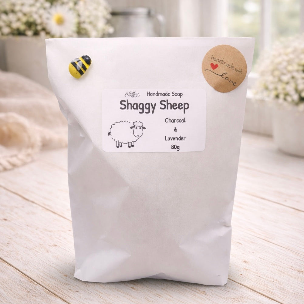 White bag of Shaggy Sheep handmade soap with a label on a light wooden surface.