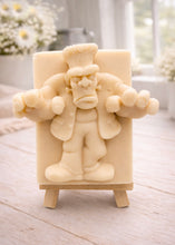 Load image into Gallery viewer, A rectangular handmade vegan soap featuring a high-relief carving of Frankenstein's monster in a classic pose with arms outstretched and a grumpy expression, displayed on a miniature wooden easel.
