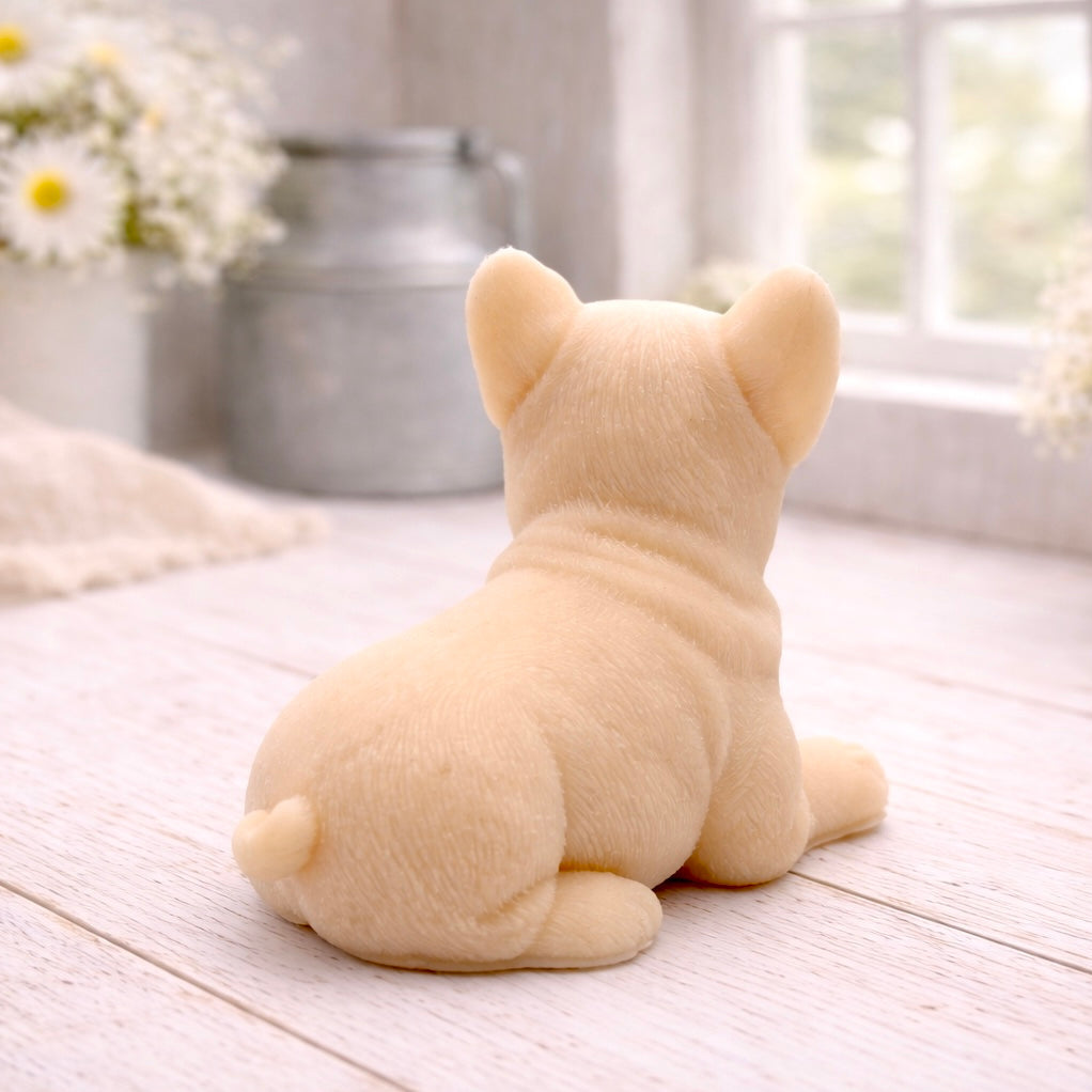 A highly detailed handmade vegan soap in a sophisticated yellow tone, sculpted in the shape of a French bulldog puppy sitting upright with its characteristic large ears and wrinkled face, displayed on a light wooden surface.