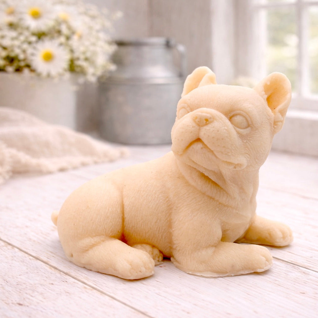 A highly detailed handmade vegan soap in a sophisticated yellow tone, sculpted in the shape of a French bulldog puppy sitting upright with its characteristic large ears and wrinkled face, displayed on a light wooden surface.