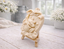 Load image into Gallery viewer, A rectangular handmade vegan soap featuring a high-relief carving of a cheerful, smiling frog sitting on a large lilypad and holding the stem of a leaf over its head like an umbrella.
