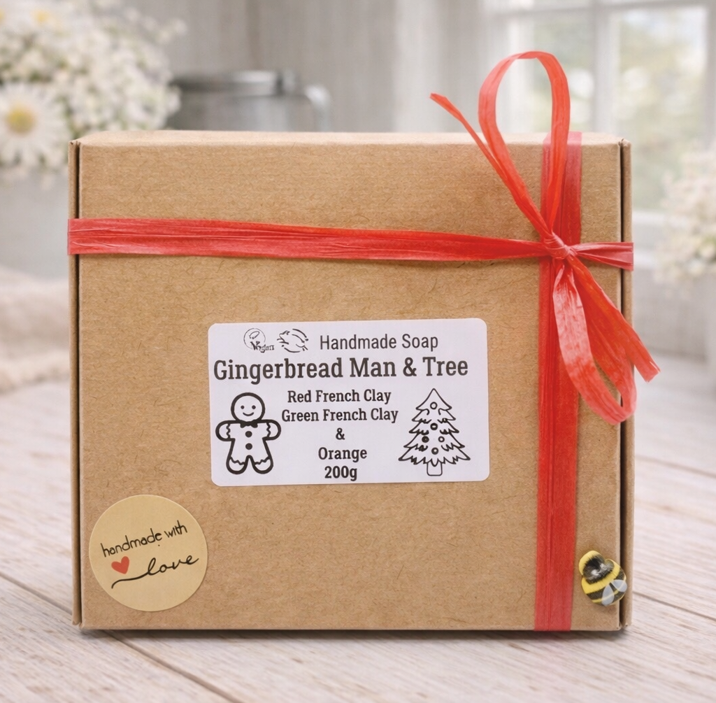 Handmade soap packaging with a gingerbread man and tree design on a wooden surface.
