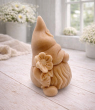 Load image into Gallery viewer, A 3D handmade vegan soap in a warm cream tone, sculpted into a cute garden gnome or gonk with a long flowing beard, a large round nose, and a tall pointed hat adorned with small embossed flowers.
