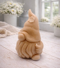Load image into Gallery viewer, A 3D handmade vegan soap in a warm cream tone, sculpted into a cute garden gnome or gonk with a long flowing beard, a large round nose, and a tall pointed hat adorned with small embossed flowers.
