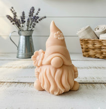 Load image into Gallery viewer, A 3D handmade vegan soap in a warm cream tone, sculpted into a cute garden gnome or gonk with a long flowing beard, a large round nose, and a tall pointed hat adorned with small embossed flowers.
