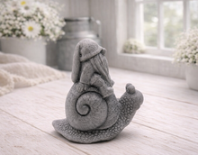 Load image into Gallery viewer, A handmade vegan soap gift, sculpted as a whimsical gnome (gonk) with a tall, slouchy hat and a long beard, sitting on the shell of a large snail with a textured, bumpy body.
