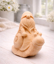 Load image into Gallery viewer, A handmade vegan soap gift, sculpted as a whimsical gnome (gonk) with a tall, slouchy hat and a long beard, sitting on the shell of a large snail with a textured, bumpy body.
