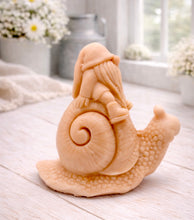 Load image into Gallery viewer, A handmade vegan soap gift, sculpted as a whimsical gnome (gonk) with a tall, slouchy hat and a long beard, sitting on the shell of a large snail with a textured, bumpy body.

