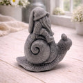 A handmade vegan soap gift, sculpted as a whimsical gnome (gonk) with a tall, slouchy hat and a long beard, sitting on the shell of a large snail with a textured, bumpy body.