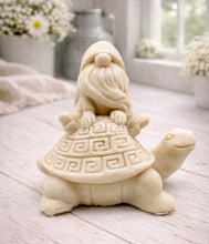 Load image into Gallery viewer, A handmade vegan soap in a natural tone, sculpted as a whimsical gnome (gonk) with a long beard sitting on the back of a large, smiling turtle with a patterned geometric shell.
