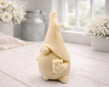 Load image into Gallery viewer, A cream-coloured handmade vegan soap sculpted as a tall, whimsical gnome (gonk) with a pointed hat and long beard, featuring a natural twine hanging rope at the top and displayed in a bright farmhouse setting.
