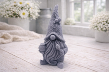 Load image into Gallery viewer, A handmade vegan soap in the shape of a gnome with a long beard, wearing a honeycomb-patterned hat with a bee, holding a honey pot and dipper.
