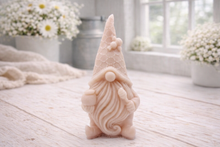 Load image into Gallery viewer, A handmade vegan soap in the shape of a gnome with a long beard, wearing a honeycomb-patterned hat with a bee, holding a honey pot and dipper.

