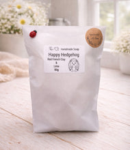 Load image into Gallery viewer, Happy Hedgehog handmade soap package on a wooden surface with a blurred background
