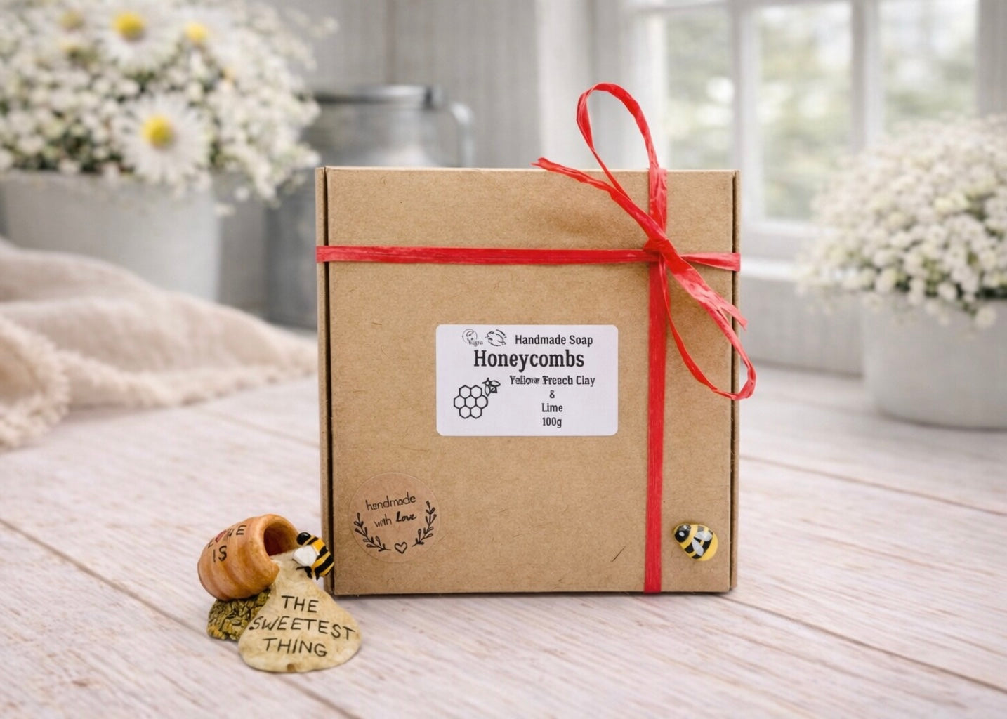 Gift box with a red ribbon and decorative elements on a wooden surface