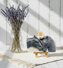 Load image into Gallery viewer, A grey and white handmade vegan soap featuring a highly detailed relief of two horses nuzzling heads, displayed on a wooden easel against a whimsical farmhouse decor background.
