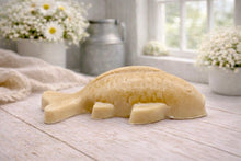 Load image into Gallery viewer, Handmade vegan soap sculpted in the shape of a koi carp fish with detailed scales and fins, resting on a light timber surface with a soft floral background.
