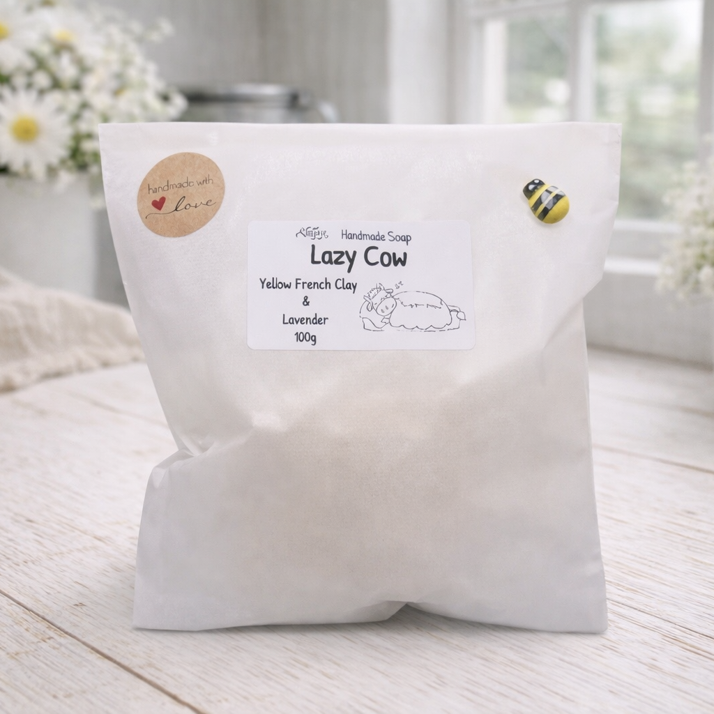 White bag labeled 'Lazy Cow' on a wooden surface with flowers in the background