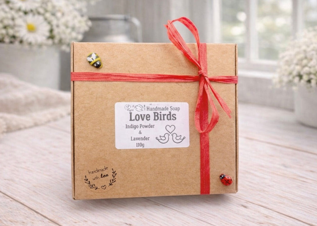 Kraft paper gift box with red ribbon and 'Love Birds' label on a wooden surface.