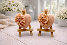 Load image into Gallery viewer, A handmade vegan soap gift set, featuring a central heart-shaped relief surrounded by a border of intricate rose flowers and delicate foliage, displayed on a small wooden easel.
