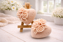 Load image into Gallery viewer, A handmade vegan soap gift set, featuring a central heart-shaped relief surrounded by a border of intricate rose flowers and delicate foliage, displayed on a small wooden easel.
