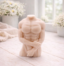 Load image into Gallery viewer, A 3D handmade vegan soap sculpted into a detailed male torso with defined chest and abdominal muscles, finished in a soft tone and displayed in a bright farmhouse setting.
