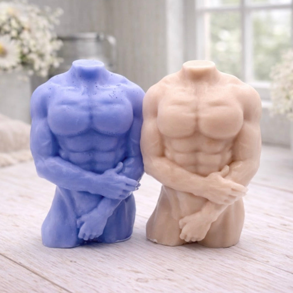 A 3D handmade vegan soap sculpted into a detailed male torso with defined chest and abdominal muscles, finished in a soft tone and displayed in a bright farmhouse setting.