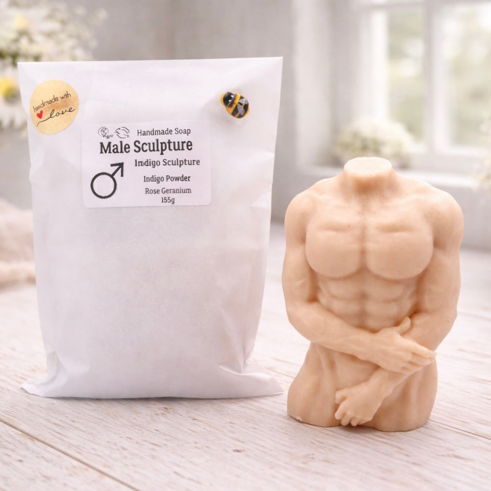 A 3D handmade vegan soap sculpted into a detailed male torso with defined chest and abdominal muscles, finished in a soft tone and displayed in a bright farmhouse setting.