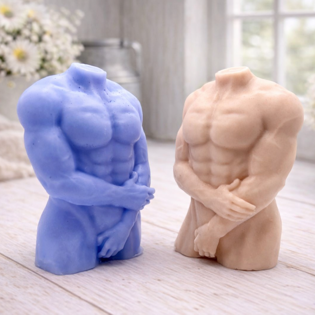 A 3D handmade vegan soap sculpted into a detailed male torso with defined chest and abdominal muscles, finished in a soft tone and displayed in a bright farmhouse setting.