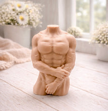 Load image into Gallery viewer, A 3D handmade vegan soap sculpted into a detailed male torso with defined chest and abdominal muscles, finished in a soft tone and displayed in a bright farmhouse setting.
