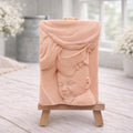 A rectangular handmade vegan soap featuring a high-relief carving of a mother tenderly cradling a small baby in her arms, displayed on a miniature wooden easel in a bright farmhouse setting.