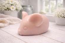 Load image into Gallery viewer, A 3D handmade vegan soap sculpted into the shape of a cute resting mouse with large rounded ears and a delicate snout, displayed on a light wooden surface in a bright farmhouse setting

