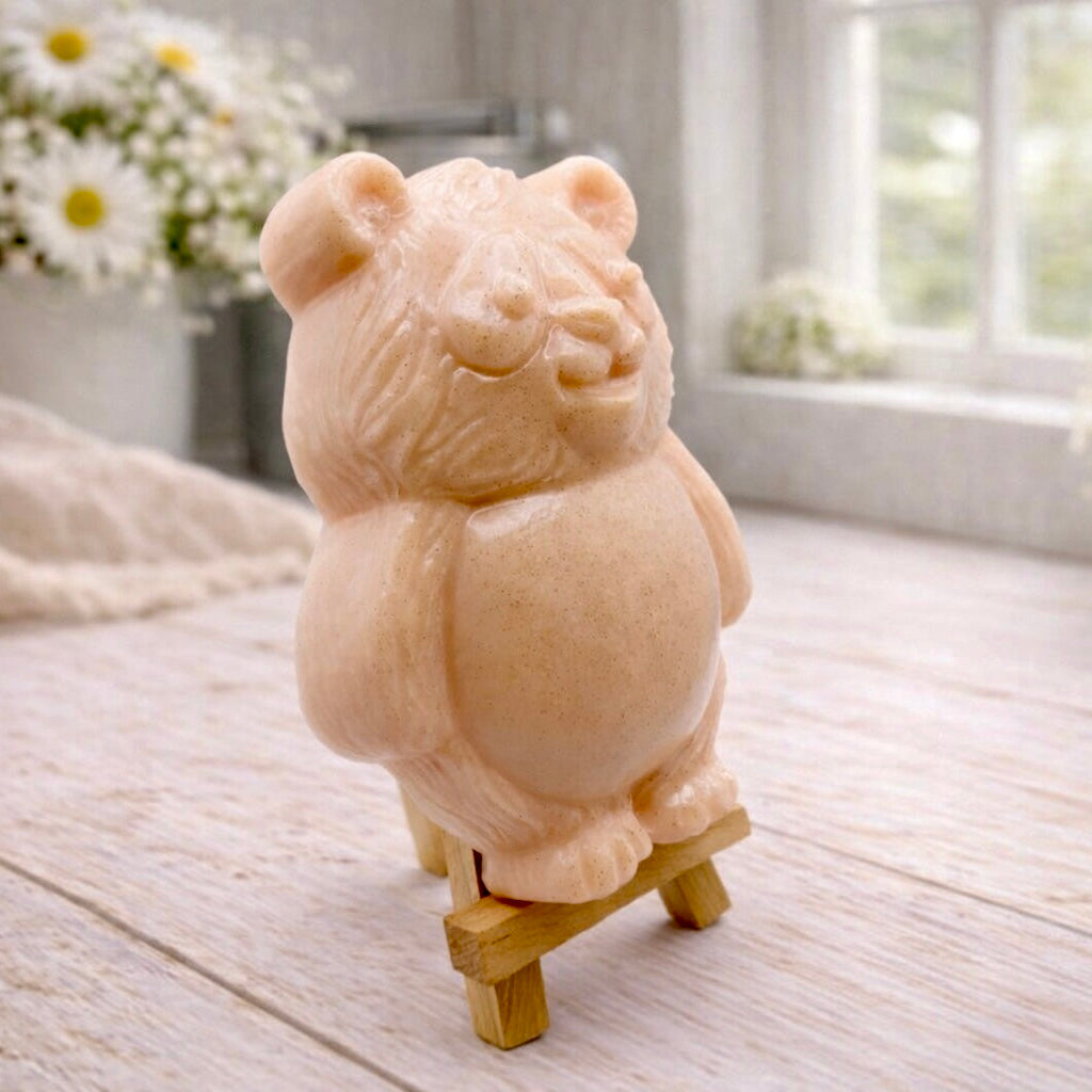 Handmade vegan soap sculpted in the shape of a round, sitting panda bear with detailed fur textures and a friendly expression, displayed on a small wooden easel.