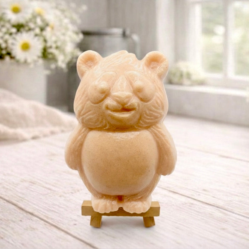 Handmade vegan soap sculpted in the shape of a round, sitting panda bear with detailed fur textures and a friendly expression, displayed on a small wooden easel.