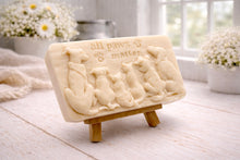 Load image into Gallery viewer, A rectangular handmade vegan soap bar gift, featuring a detailed relief carving of several dogs and a cat sitting together, with the words "all paws matter" and two paw prints embossed at the top, displayed on a wooden easel. Made in Blackpool. 
