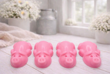 Load image into Gallery viewer, A charming collection of four handmade vegan soaps featuring four piglets, each intricately sculpted with realistic textures and playful expressions, arranged on a light wooden surface.
