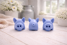 Load image into Gallery viewer, A set of three handmade vegan soaps sculpted into cute pigs with round snouts and floppy ears, displayed with a small decorative bee and ladybird on a white wooden surface.
