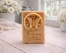 Load image into Gallery viewer, Bar of soap with butterfly design and 'Embrace Your Dreams' text on a wooden surface.
