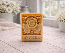 Load image into Gallery viewer, Bar of soap with floral design and 'Life is Good' text on a wooden surface.
