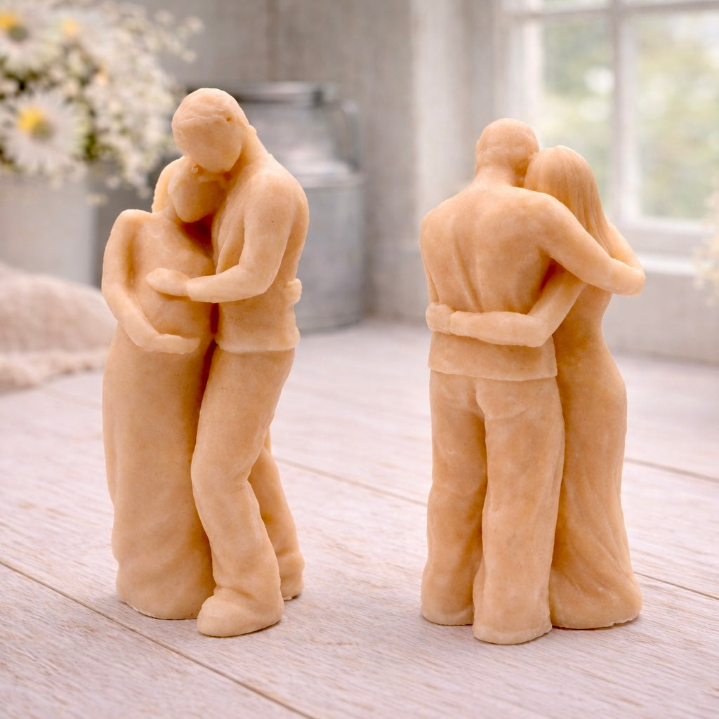 A 3D handmade vegan soap in a warm cream tone, sculpted into a standing figure of a pregnant couple; the partner stands behind the expectant mother, tenderly cradling her baby bump, displayed on a light wooden surface in a bright farmhouse setting.