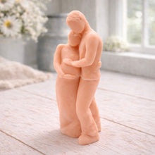 Load image into Gallery viewer, A 3D handmade vegan soap in a warm cream tone, sculpted into a standing figure of a pregnant couple; the partner stands behind the expectant mother, tenderly cradling her baby bump, displayed on a light wooden surface in a bright farmhouse setting.

