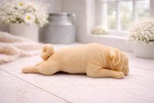 Load image into Gallery viewer, A detailed handmade vegan soap gift, sculpted in the shape of a pug dog lying flat on its stomach in a sleeping position, showing realistic skin folds and fur texture, displayed on a light wooden surface. Handmade in Blackpool 
